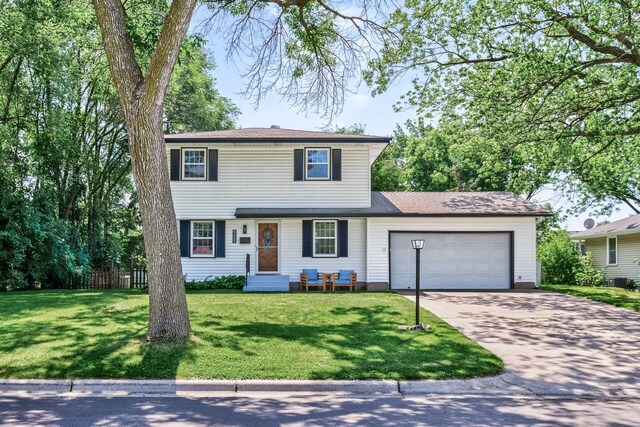 4309 78th Ave N, Brooklyn Park, MN 55443 - colonial-style house with an attached garage, driveway, a front lawn, and roof with shingles