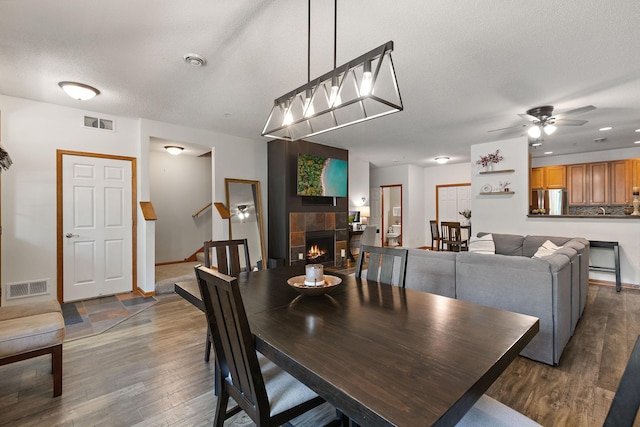 4940 Underwood Ln N Unit 4940B, Plymouth, MN 55442 - dining space with a tiled fireplace, dark wood-style floors, ceiling fan, stairs, and a textured ceiling