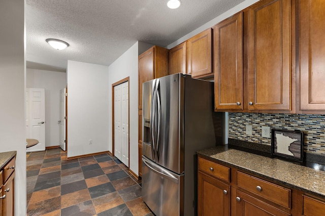 4940 Underwood Ln N Unit 4940B, Plymouth, MN 55442 - kitchen featuring stainless steel fridge with ice dispenser, brown cabinetry, a textured ceiling, decorative backsplash, and dark stone countertops