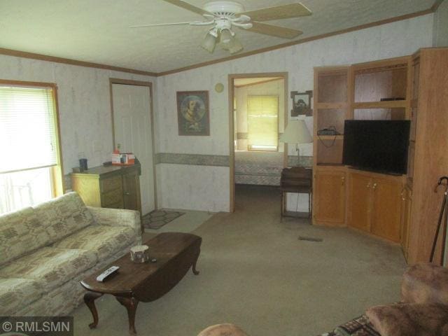 32546 360th St, Kimberly Twp, MN 56431 - living area with ornamental molding, light colored carpet, a ceiling fan, wallpapered walls, and vaulted ceiling