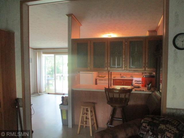 32546 360th St, Kimberly Twp, MN 56431 - kitchen featuring a kitchen bar, a peninsula, and glass insert cabinets