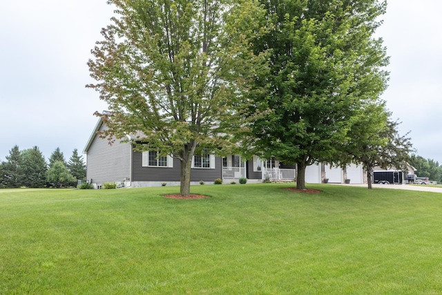 1902 11th Ave NE, Kasson, MN 55944 - obstructed view of property featuring a front lawn, covered porch, and a garage