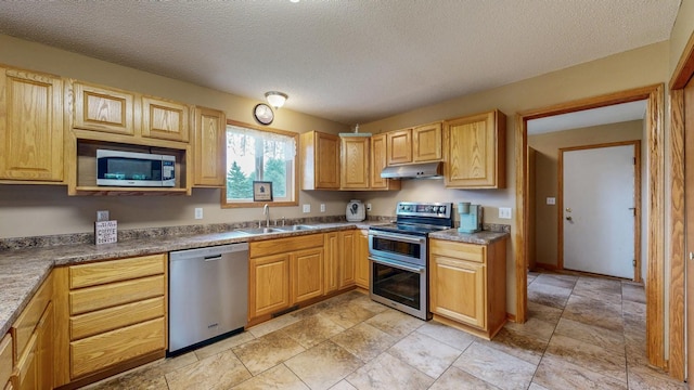 1902 11th Ave NE, Kasson, MN 55944 - kitchen with appliances with stainless steel finishes, under cabinet range hood, a textured ceiling, and light stone finish flooring