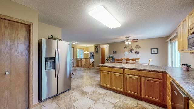 1902 11th Ave NE, Kasson, MN 55944 - kitchen featuring stainless steel appliances, a peninsula, a ceiling fan, a textured ceiling, and brown cabinetry