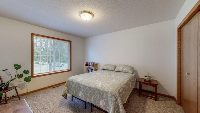 1902 11th Ave NE, Kasson, MN 55944 - bedroom with carpet flooring, a closet, and a textured ceiling