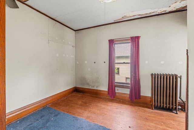 2416 13th Ave S, Minneapolis, MN 55404 - unfurnished room featuring radiator heating unit and wood finished floors