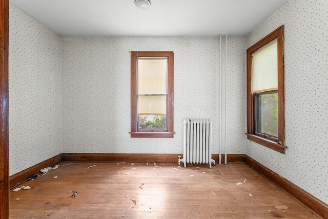 2416 13th Ave S, Minneapolis, MN 55404 - empty room featuring radiator and hardwood / wood-style floors