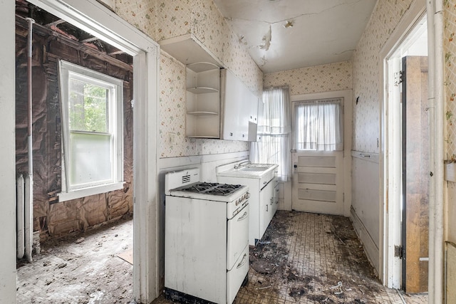 2416 13th Ave S, Minneapolis, MN 55404 - kitchen with wallpapered walls, white gas range oven, open shelves, white cabinetry, and light countertops