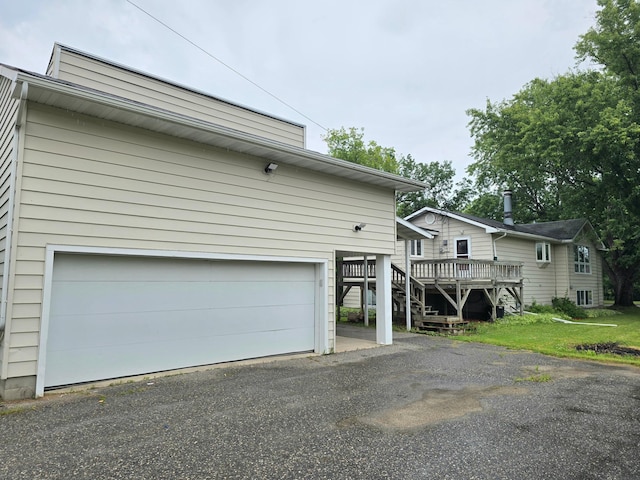 1218 2nd Ave E, International Falls, MN 56649 - view of front of property featuring a garage, a deck, driveway, and stairs