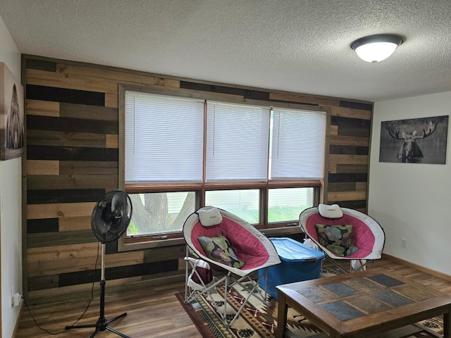 1218 2nd Ave E, International Falls, MN 56649 - sitting room featuring wooden walls, a textured ceiling, and wood finished floors