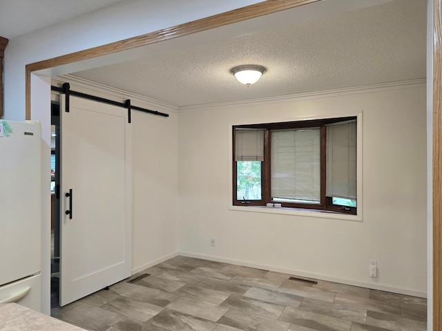 1218 2nd Ave E, International Falls, MN 56649 - unfurnished bedroom with freestanding refrigerator, a barn door, ornamental molding, and a textured ceiling