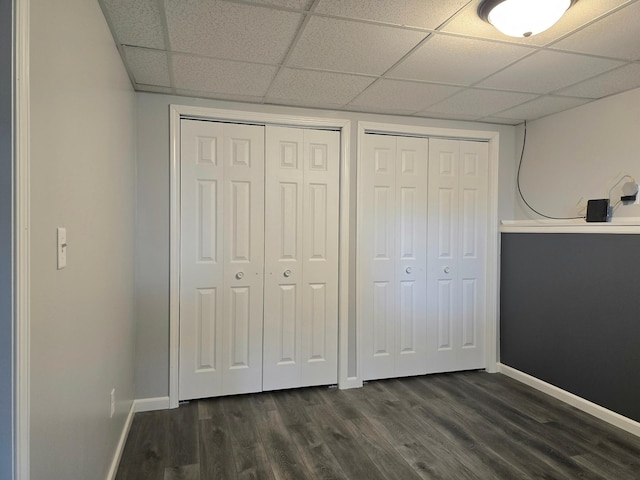 1218 2nd Ave E, International Falls, MN 56649 - unfurnished bedroom with two closets, a paneled ceiling, and dark wood-style floors