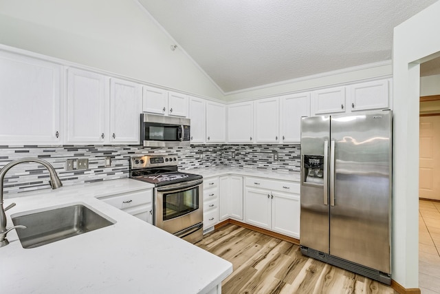 6873 Benton Way Unit 59, Inver Grove Heights, MN 55076 - kitchen with stainless steel appliances, lofted ceiling, white cabinetry, decorative backsplash, and a textured ceiling