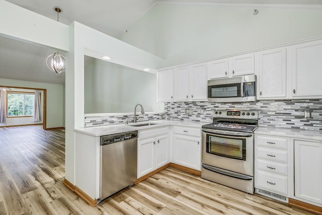 6873 Benton Way Unit 59, Inver Grove Heights, MN 55076 - kitchen with appliances with stainless steel finishes, vaulted ceiling, light countertops, white cabinets, and light wood-type flooring