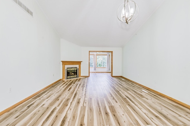 6873 Benton Way Unit 59, Inver Grove Heights, MN 55076 - unfurnished living room featuring a chandelier, light wood-style floors, a fireplace with flush hearth, and vaulted ceiling