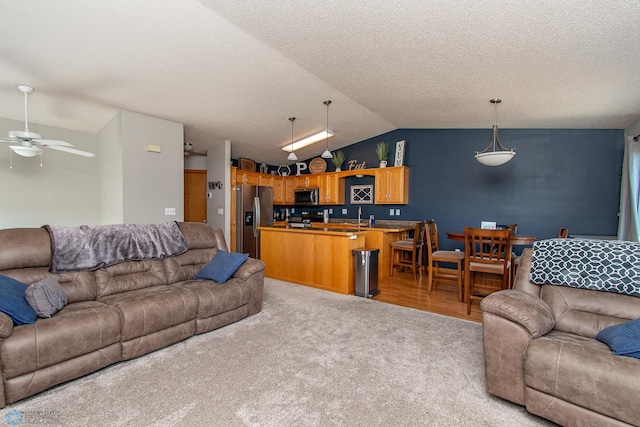3590 Fillmore St S, Fargo, ND 58104 - living room featuring ceiling fan, vaulted ceiling, light carpet, and a textured ceiling