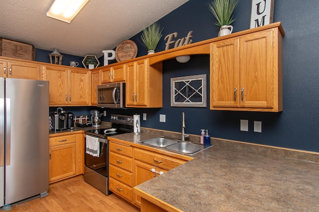 3590 Fillmore St S, Fargo, ND 58104 - kitchen featuring stainless steel appliances, a textured ceiling, dark countertops, and light wood-style floors
