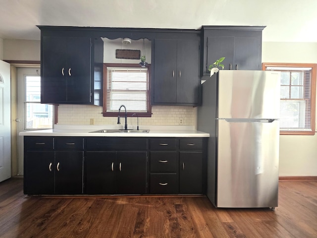 3709 Quail Ave N, Robbinsdale, MN 55422 - kitchen with freestanding refrigerator, light countertops, backsplash, and dark wood-style flooring