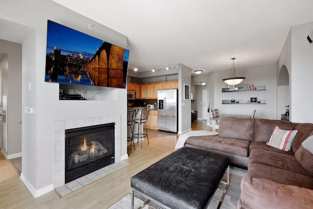 500 Grant St Unit 1105, Minneapolis, MN 55404 - living room with light wood-style floors, arched walkways, rail lighting, and a fireplace