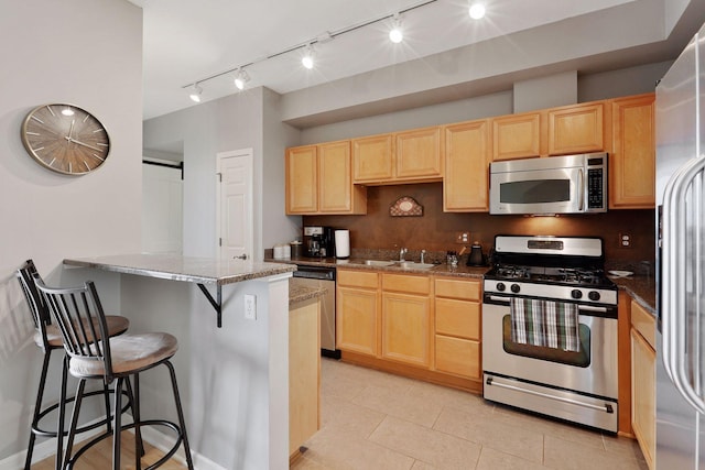 500 Grant St Unit 1105, Minneapolis, MN 55404 - kitchen with light brown cabinetry, stainless steel appliances, rail lighting, a breakfast bar area, and a peninsula