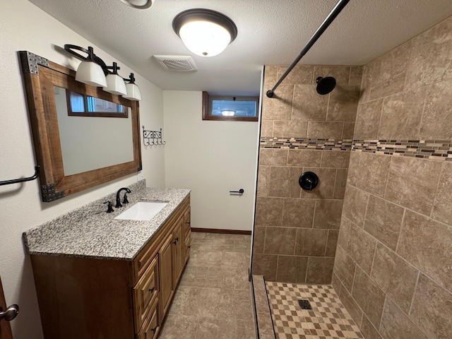 90760 US Highway 71, Christiania Twp, MN 56101 - bathroom with vanity, tiled shower, a textured ceiling, and tile patterned flooring