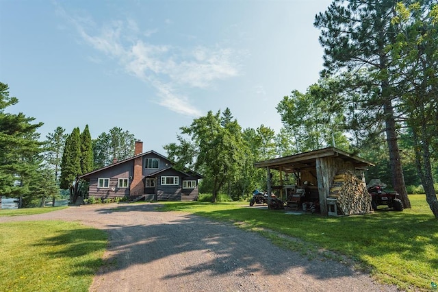 5607 Skogvei Rd, Duluth, MN 55803 - view of front facade with driveway, a front yard, and a chimney