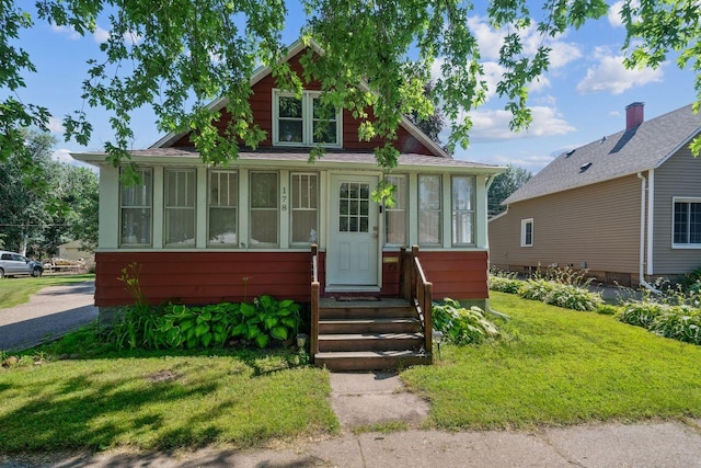 178 Mainzer St, West Saint Paul, MN 55118 - bungalow-style house featuring a sunroom, a front lawn, and entry steps