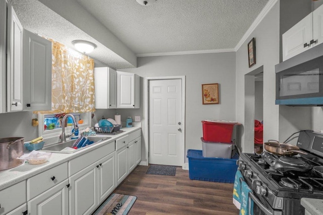 4111 Bryant Ave N, Minneapolis, MN 55412 - kitchen with appliances with stainless steel finishes, a textured ceiling, crown molding, white cabinetry, and light countertops