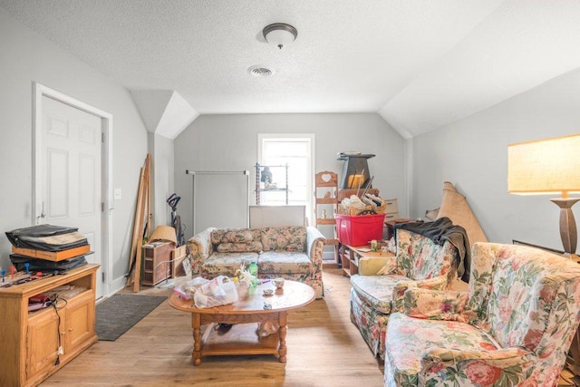 4111 Bryant Ave N, Minneapolis, MN 55412 - living area featuring vaulted ceiling, light wood-style flooring, and a textured ceiling
