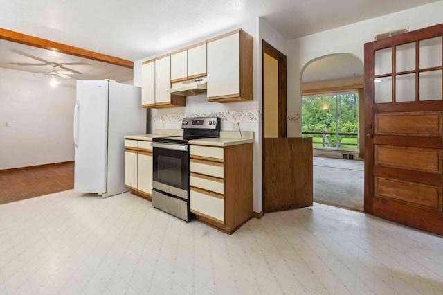 13425 Pillager Dam Rd SW, Sylvan Twp, MN 56473 - kitchen featuring stainless steel range with electric cooktop, arched walkways, freestanding refrigerator, light countertops, and under cabinet range hood