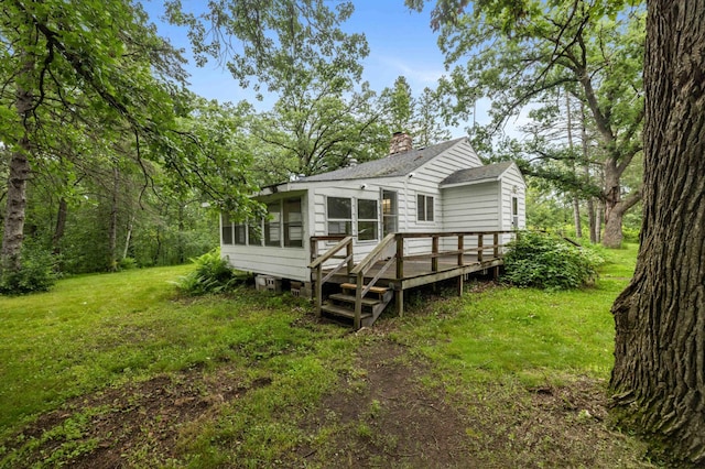 13425 Pillager Dam Rd SW, Sylvan Twp, MN 56473 - rear view of property with a wooden deck, a sunroom, a chimney, a shingled roof, and a yard
