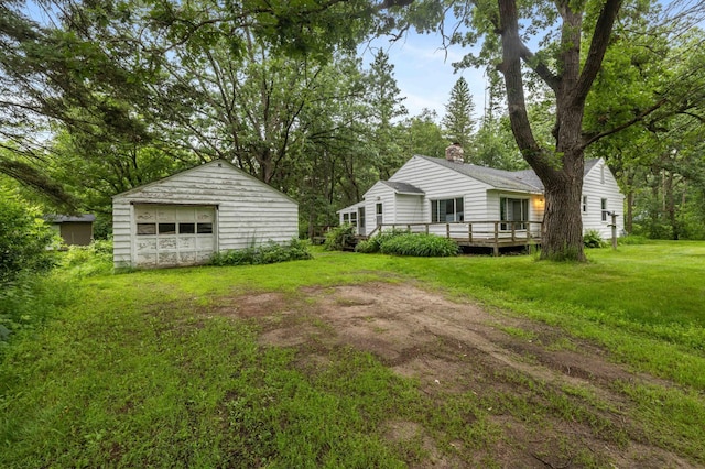13425 Pillager Dam Rd SW, Sylvan Twp, MN 56473 - view of grassy yard with a detached garage, an outdoor structure, a deck, and driveway