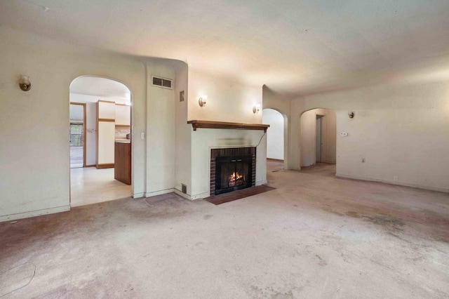 13425 Pillager Dam Rd SW, Sylvan Twp, MN 56473 - unfurnished living room featuring arched walkways, a fireplace, and carpet