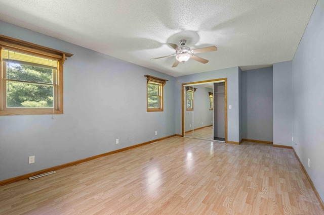 51800 500th St, Menahga, MN 56464 - unfurnished bedroom featuring a textured ceiling, light wood-type flooring, ceiling fan, and a closet