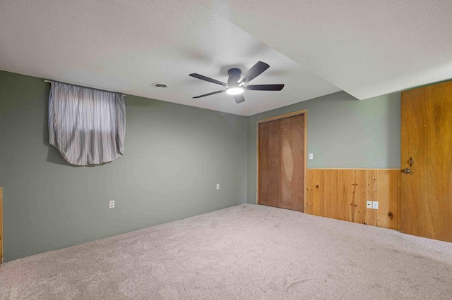 51800 500th St, Menahga, MN 56464 - unfurnished bedroom featuring carpet, a textured ceiling, a wainscoted wall, a closet, and ceiling fan