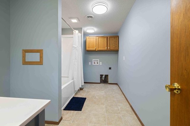 51800 500th St, Menahga, MN 56464 - laundry room featuring cabinet space, hookup for a washing machine, electric dryer hookup, a textured ceiling, and light tile patterned floors