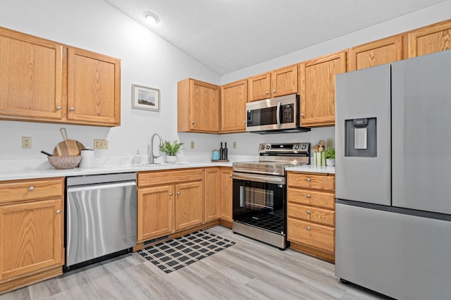 8811 Coffman Path, Inver Grove Heights, MN 55076 - kitchen with stainless steel appliances, vaulted ceiling, light wood-style flooring, and light countertops