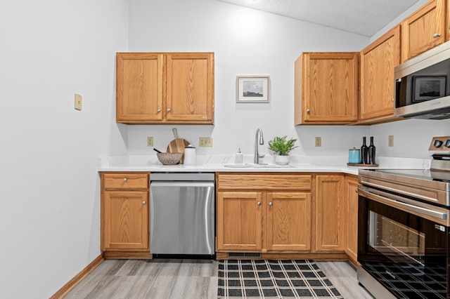 8811 Coffman Path, Inver Grove Heights, MN 55076 - kitchen featuring appliances with stainless steel finishes, vaulted ceiling, light countertops, and light wood finished floors