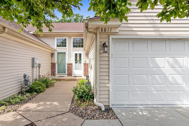 8811 Coffman Path, Inver Grove Heights, MN 55076 - property entrance with a shingled roof, brick siding, and a garage