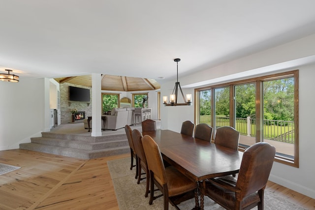 8045 County Road 116, Corcoran, MN 55340 - dining room with a chandelier, a stone fireplace, and light wood-type flooring