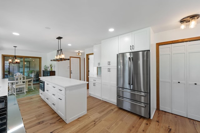 8045 County Road 116, Corcoran, MN 55340 - kitchen with a chandelier, stainless steel fridge, light wood-style flooring, light countertops, and white cabinets