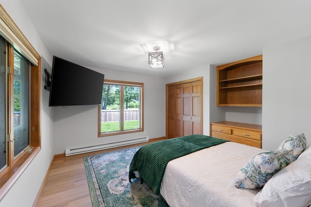 8045 County Road 116, Corcoran, MN 55340 - bedroom featuring a baseboard heating unit, light wood finished floors, and a closet