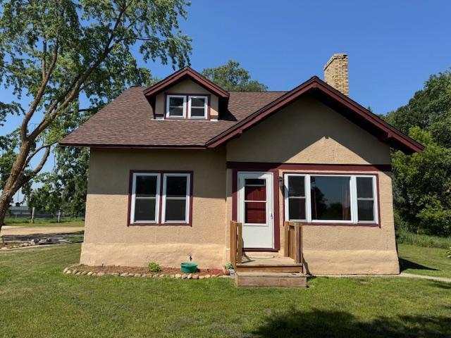 31845 615th Ave, Compton Twp, MN 56482 - bungalow featuring stucco siding, a front lawn, a chimney, and roof with shingles