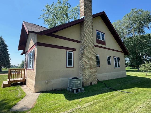 31845 615th Ave, Compton Twp, MN 56482 - view of property exterior featuring stucco siding, a chimney, and a yard