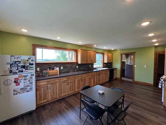 31845 615th Ave, Compton Twp, MN 56482 - kitchen with freestanding refrigerator, dark countertops, dark wood-style floors, decorative backsplash, and recessed lighting