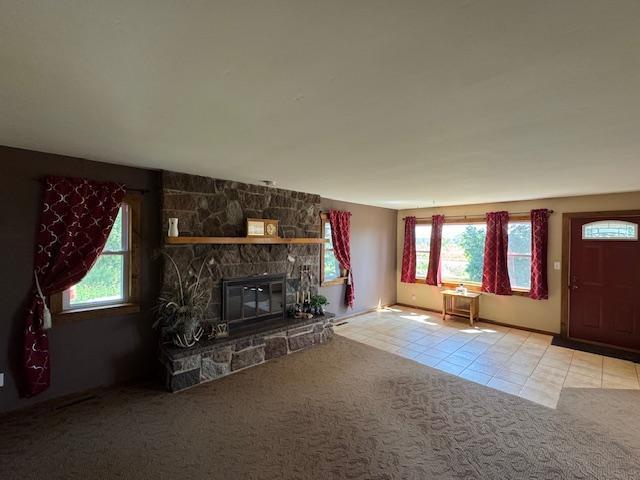 31845 615th Ave, Compton Twp, MN 56482 - unfurnished living room with tile patterned floors, healthy amount of natural light, carpet, and a fireplace