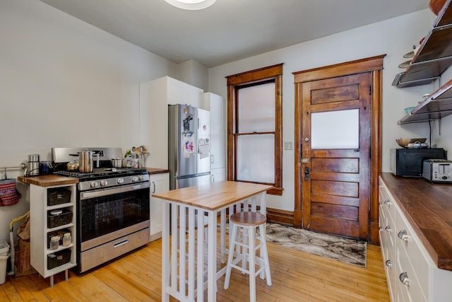 400 8th Ave NE Unit 1, Minneapolis, MN 55413 - kitchen featuring wooden counters, gas stove, light wood finished floors, and freestanding refrigerator