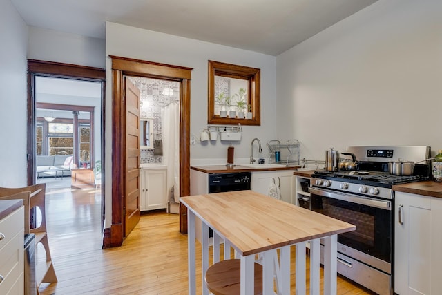 400 8th Ave NE Unit 1, Minneapolis, MN 55413 - kitchen with gas stove, butcher block countertops, light wood-type flooring, and white cabinets