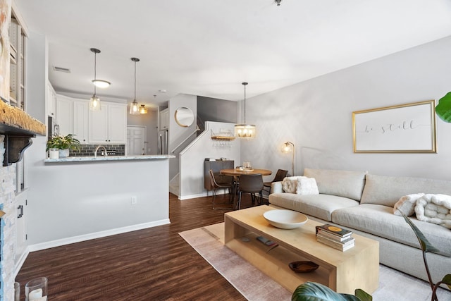 660 2nd St Unit 104, Minneapolis, MN 55401 - living room featuring dark wood-style floors, a chandelier, and stairs