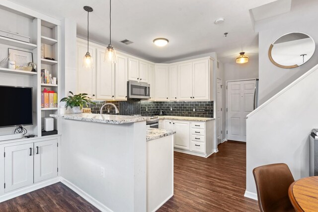 660 2nd St Unit 104, Minneapolis, MN 55401 - kitchen featuring a peninsula, dark wood-style floors, stainless steel microwave, and white cabinetry